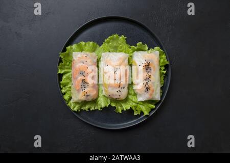 Vietnamese spring rolls with shrimp in center of black table. View from above. Asian cuisine. Horizontal orientation. Stock Photo