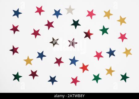 Colorful stars confetti or glitter on white background, isolated. Stylish atmospheric image. Happy birthday concept. Holiday decorations. Magic and Ch Stock Photo