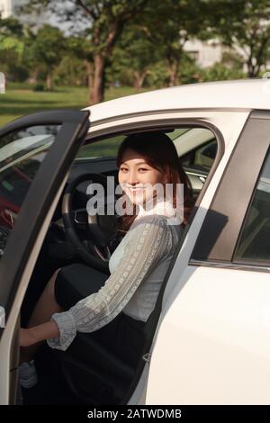 Photo of happy young mixed race woman sitting inside her new car. Concept for car rental Stock Photo