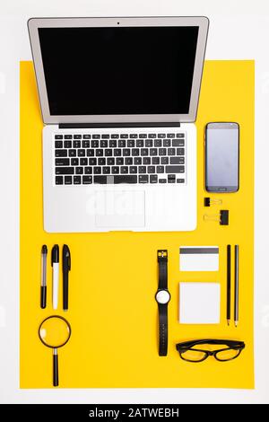 office workplace. stationery with laptop, credit card with mockup, phone and magnifying glass lie on the table Stock Photo