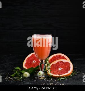 Fresh grapefruit juice in a glass. Top view. On a black background. Stock Photo