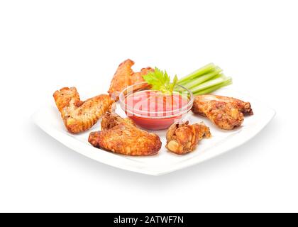 Hot Fried Crispy Chicken Wings in batter on a white plate with celery sticks and ketchup. Breaded Crunchy Meat Made of Chicken Wings. Isolated Stock Photo