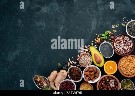 Superfoods Healthy food. Nuts, berries, fruits, and legumes. On a black stone background. Top view. Free copy space. Stock Photo