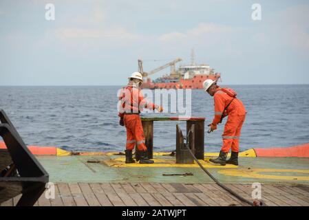 marine crew doing anchor handling operation at sea for four point mooring anchor work boat at sea Stock Photo