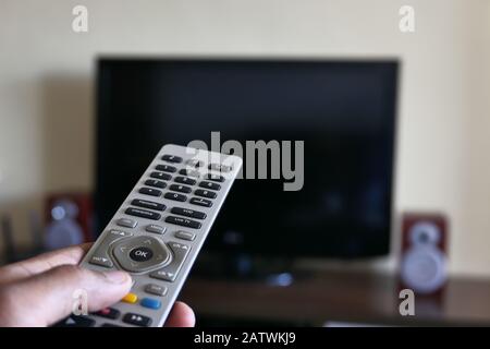 Closeup of man hand using Tv remote  Stock Photo