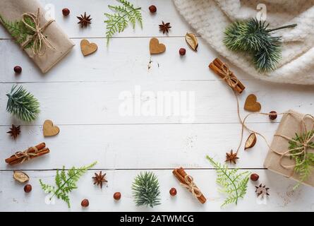 Flat lay background. Gift boxes are packed in craft paper and simple decor with green cinnamon and guavas on a wooden background Stock Photo