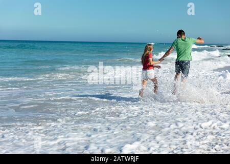 Young couple running in the water Stock Photo