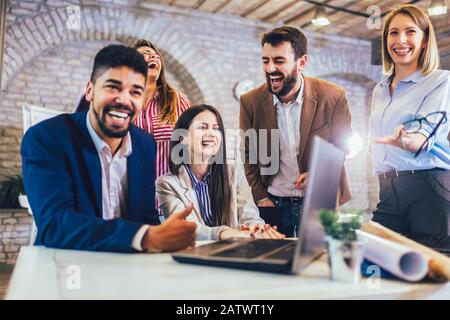 Young team of coworkers making great meeting discussion in modern coworking office. Stock Photo