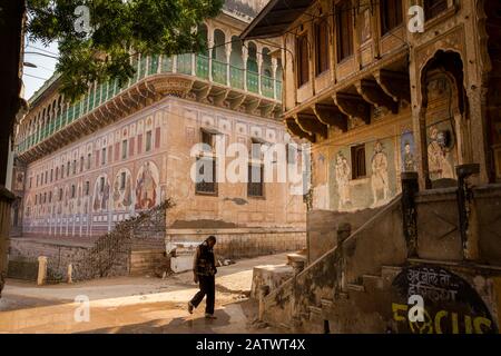 India, Rajasthan, Shekhawati, Dundlod, man walking between old painted Havelis Stock Photo