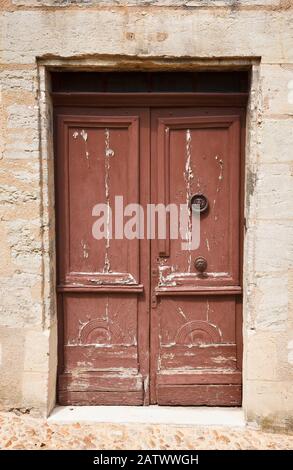 Old wooden door set in a stone wall in Europe Stock Photo