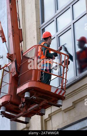 Window washer works on truck mounted lift Stock Photo