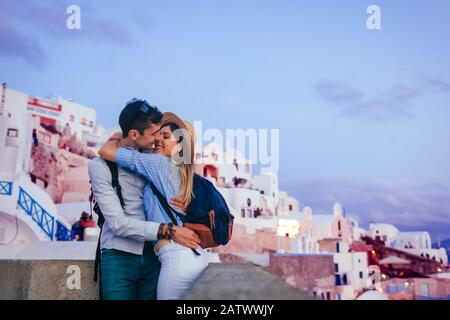 Valentine's day in Oia. Couple in love enjoying honeymoon on Santorini island Greece at sunset. Vacation and traveling Stock Photo