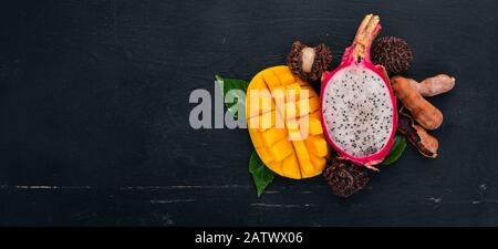 Mango and Dragon Fruit. Fresh Tropical Fruits. On a wooden background. Top view. Copy space. Stock Photo