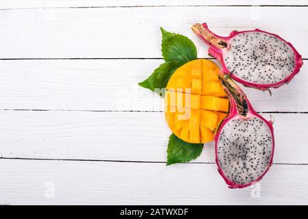 Mango and Dragon Fruit. Fresh Tropical Fruits. On a wooden background. Top view. Copy space. Stock Photo