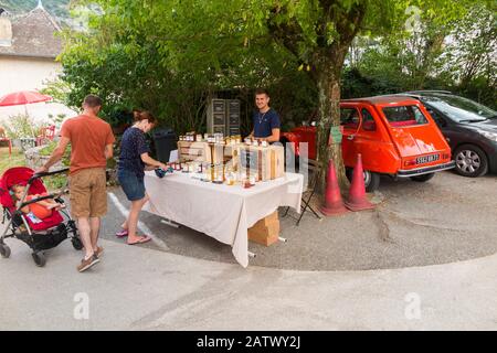 Market stall seller selling honey to tourists in Chanaz; French commune in the Savoie department in the Auvergne-Rhône-Alpes region in south-eastern France. (112) Stock Photo
