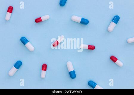 Drugs pills capsules on blue background abstract top view medicine health concept Stock Photo