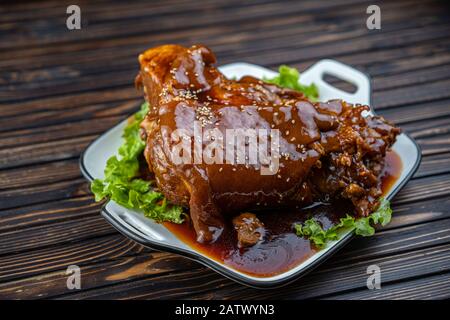 Roast pork knuckle served with boiled cabbage, bread, horseradish and mustard. Stock Photo