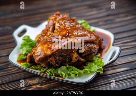 Roast pork knuckle served with boiled cabbage, bread, horseradish and mustard. Stock Photo