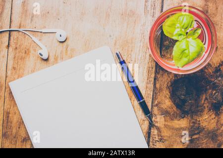 Office stuff with notepad, pen, hand, glass of water with fresh mint. Top view shot. Retro concept. Stock Photo