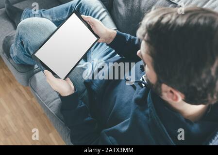 high angle view of man relaxing on couch while using tablet computer Stock Photo
