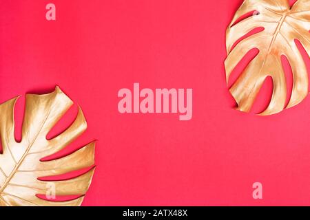 Painted in golden color tropical palm monstera leaf on red background. Shiny and sparkle design, fashion concept Stock Photo