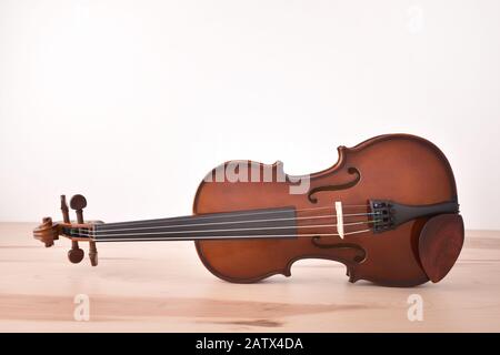 Violin on wooden table and white background. Horizontal composition. Front view Stock Photo