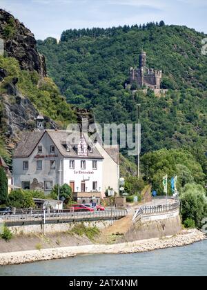EHRENTHAL, GERMANY -  JULY 06, 2019:  The riverside restaurant Klosterschenke  with Maus Castle set on a hillside overlooking the Rhine River