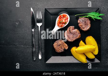 Veal medallions on a wooden background. Top view. Free space for text ...