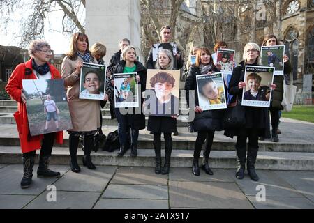 Activists hold placards in Old Palace Yard, Westminster, as families with severely epileptic children hand in a petition to 10 Downing Street, London, calling for access to medical cannabis on the NHS. Stock Photo