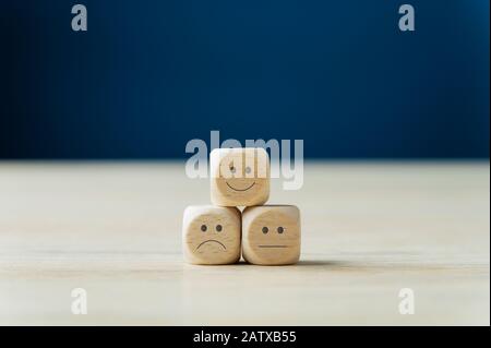 Customer service satisfaction concept - three wooden dices with different expressions of satisfaction on them. Stock Photo