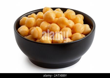 Cooked chick peas in a black ceramic bowl isolated on white. Stock Photo