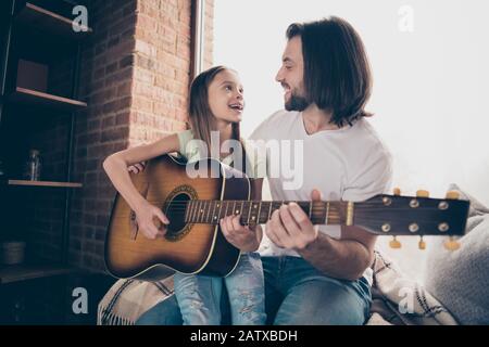 Photo of little adorable pretty lady and her handsome attractive young daddy sit window sill look eyes hold acoustic guitar learn new song spend time Stock Photo