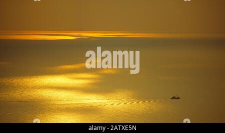 Channel Islands. Guernsey. Atlantic Ocean sunset with fishing trawler. Stock Photo