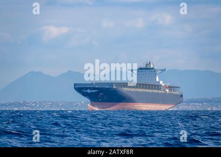 Sunny summer day and calm sea. Empty cargo ship in the Mediterranean sea Stock Photo