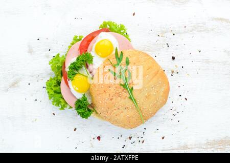 Burger with fried egg and sausage. Breakfast. Top view. Free space for your text. Stock Photo