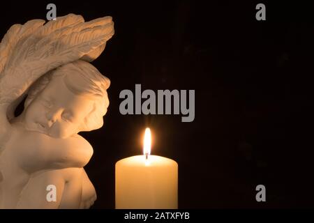 Angel and candle on dark background Stock Photo