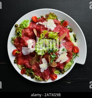 Veal carpaccio. Veal with capers and parmesan cheese. Top view. Free copy space. Stock Photo