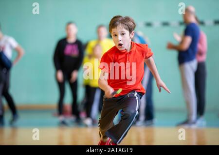 Child in the gym. A schoolboy in a physical education lesson. Relay race in elementary school. The boy goes in for sports. Children's training. Sports Stock Photo