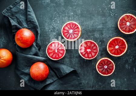 Flat lay food composition with blood oranges on a dark blue background. Stock Photo