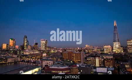 London at dusk. Wide angle panoramic view of the UK capital skyline including illuminated City of London skyscrapers and the Shard Building. Stock Photo