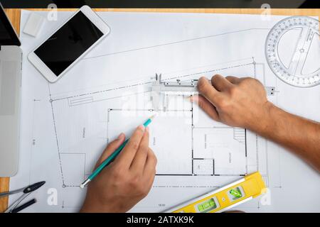 Top view of Confident team of architect working together on blueprint.They discussing about new startup project on desk, architectural concept Stock Photo