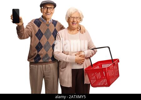 Elderly man holding a mobile phone and a senior woman with an empty shopping basket isolated on white background Stock Photo