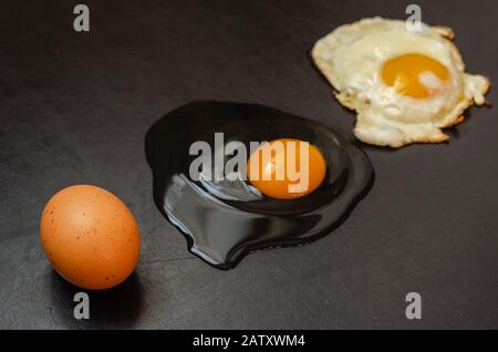 Lined line of whole chicken egg, raw broken and fried eggs. Side view. Selective focus. Close-up. Stock Photo