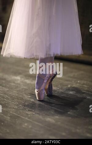 The legs of the ballerina in pointe standing in the rehearsal hall of the theater Stock Photo