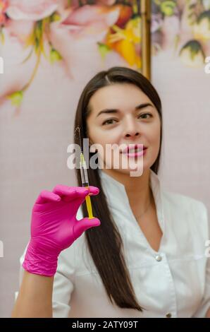female doctor holds a medical syringe in front of her Stock Photo