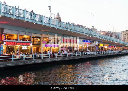 ISTANBUL - MAY 24: Tourists relax in the restaurants located on the first level of the famous Galata Bridge at night on may 24, 2013 in Istanbul, Turk Stock Photo