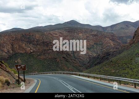 Route 62 with sign showing lay-by in 1km at Huisrivier Pass (Huisrivierpas), between the towns of Ladismith and Calitzdorp,Little Karoo, South Africa Stock Photo