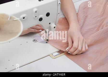 Woman using sewing machine in tailor studio or modern atelier shop Stock Photo