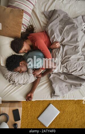High angle view of young family relaxing in bed they embracing each other and sleeping Stock Photo