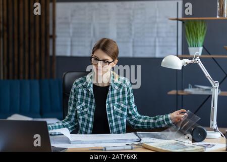 Interior designer working in office with blueprints.Engineer inspect architectural plan, sketching a construction project.Portrait of beautiful woman Stock Photo